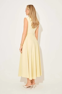 Elegant pale yellow sleeveless midi dress featuring a cinched waist and pleated skirt detail