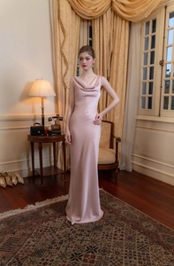 Détail du col bénitier et du tissu en satin brillant sur la robe de soirée rose pâle