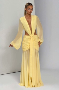 Dettaglio dell'abito maxi in chiffon giallo tenue con scollo a V profondo e vita con ritagli