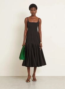 Detail of elegant black pleated maxi dress with camisole neckline and flowing skirt