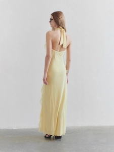 Elegant back view of yellow backless halter maxi dress with ruffle detailing