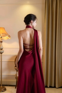 Détail de robe de soirée dos nu en satin bordeaux avec fines bretelles croisées