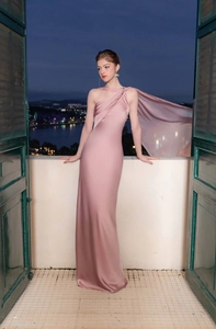 Detail of elegant dusty pink satin formal gown with one-shoulder design and flowing cape