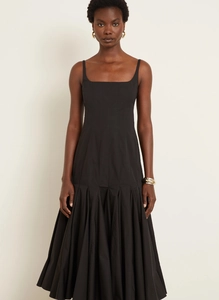 Detailed view of the elegant pleated flare skirt and waist design of this black midi dress