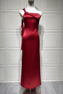 Détail du drapé en satin rouge de haute qualité et de la texture lisse et brillante de la robe