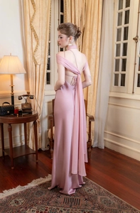 Detail of elegant pink satin backless gown featuring a long flowing sash for a formal gala