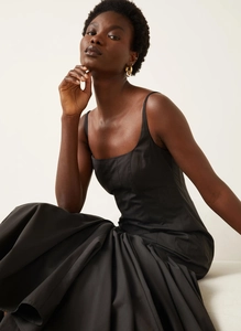 Detail of elegant black French slip dress with structured bodice and flowy hemline