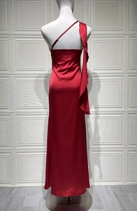 Détail de l'élégante robe longue en satin rouge avec une épaule dénudée à volants