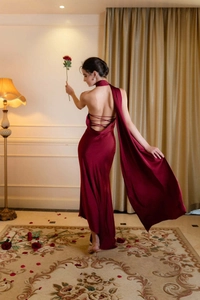 Robe de soirée élégante en satin bordeaux avec dos nu et détail de cape fluide latérale