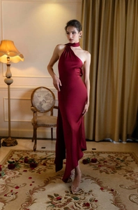 Détail de la robe de soirée élégante en satin bordeaux avec col licou et ourlet
