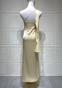 Détail d'une robe longue en satin champagne avec épaule à volants et fente latérale