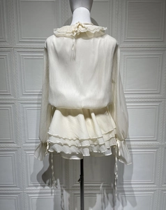 Vue détaillée du dos d'une robe blanche à volants étagés avec manches lanternes en mousseline