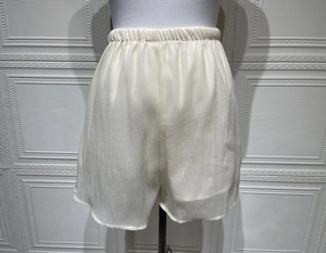 Détail de la taille haute élastique et du tissu doux de ce short ample blanc cassé