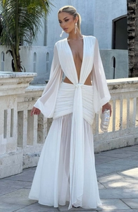 Dettaglio dell'abito bianco in chiffon con profondo scollo a V, ritagli in vita e maniche a sbuffo