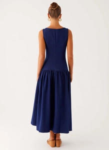Detail view of navy blue sleeveless maxi dress with low waist pleating and draped skirt