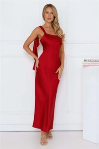 Détail de la robe en satin rouge avec bretelle asymétrique et détail de ruban élégant