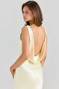 Detail of the deep U-shaped backless design on a light yellow satin evening dress