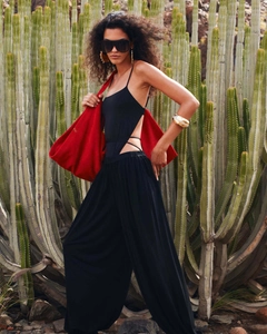 Combinaison noire chic avec découpe, pantalon large et un grand sac fourre-tout rouge