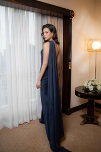 Detail of navy blue satin evening dress featuring an elegant backless design and cape