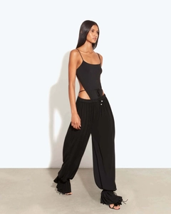 Détail d'un body noir dos nu avec découpes et pantalon assorti à jambes larges évasées