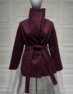 Detailed view of burgundy wool coat featuring high stand collar and belted waist design