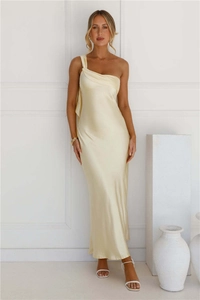 Détail d'une robe longue en satin avec plis élégants à l'épaule et tissu satiné champagne brillant