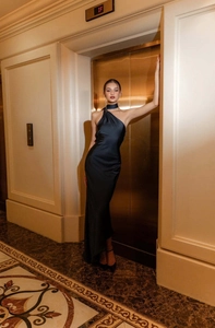 Détails de la robe de soirée noire en satin avec dos nu élégant et coupe longue fluide