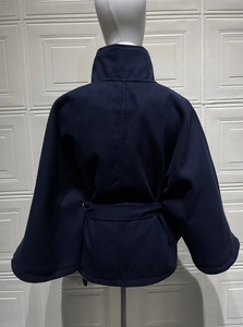 Rear view of dark blue woolen cloak coat featuring batwing sleeves and matching waist belt