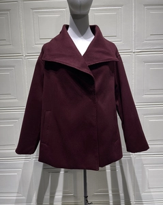 Front view of deep red wool coat detail showing wide lapels and premium thick texture