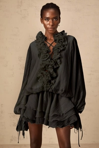 Détail d'une robe noire à col en V avec volants floraux 3D et manches lanternes