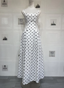 Détail de la robe blanche à pois avec encolure carrée et coupe ajustée à la taille élégante