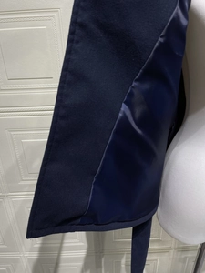 Detail view of the navy blue wool coat showing the high-quality satin lining and stitching