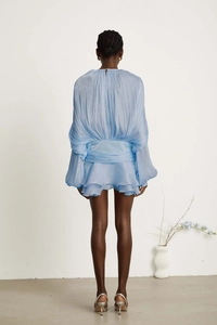 Detail of light blue puff sleeve dress showing back button closure and shiny fabric texture