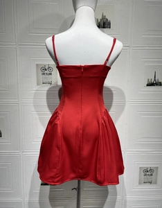 Detail of red backless mini dress featuring thin straps and hidden back zipper closure