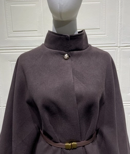 Detailed view of dark purple wool cape coat with vintage metal button and slim waist belt