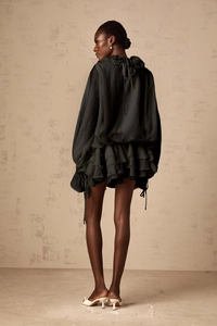 Détails de robe à volants vert foncé avec manches lanternes et tissu en mousseline texturée