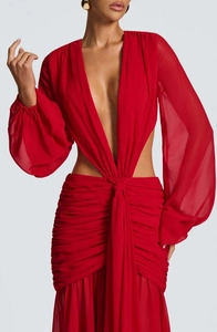 Dettaglio dell'abito lungo rosso in chiffon con scollo a V profondo e vita con cut-out
