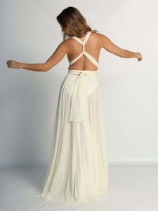 Elegant white backless halter maxi dress with criss-cross straps and pleated flowing skirt