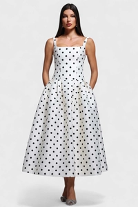 Détail de la robe blanche à pois avec de larges bretelles et des poches latérales invisibles