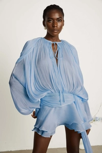 Close-up of light blue pleated fabric texture with elegant lantern sleeves and waist ties