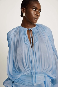 Detail of light blue pleated puff sleeve dress featuring a keyhole neckline with tie closure