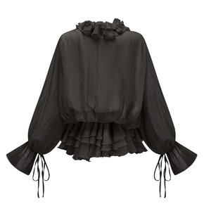 Détail du dos d'une blouse noire à volants avec ourlet superposé et longs lacets