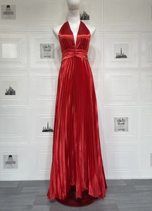 Détail d'une robe maxi plissée en satin rouge avec taille haute et texture soyeuse