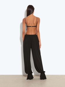 Vue arrière d'une combinaison noire dos nu avec fines bretelles et pantalon large fluide