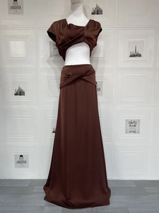 Detail eines braunen Satin-Zweiteilers mit verdrehtem Crop-Top und drapiertem Maxirock