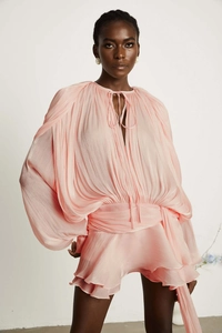 Close-up of pleated texture on a pink puff sleeve dress with waist tie and ruffles
