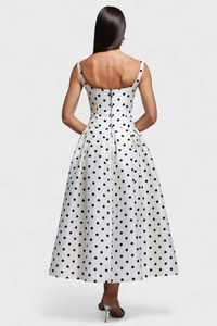 Détail d'une robe blanche à pois avec fermeture éclair au dos et jupe évasée en ligne A