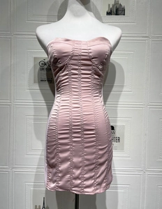 Detailed view of pink satin strapless dress featuring vertical ruching and glossy fabric