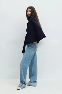 Detail of high neck button cape coat in navy blue with belted waist and batwing sleeves