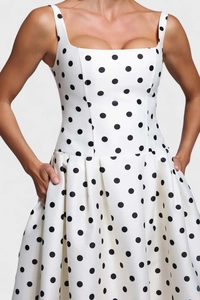 Détail de la robe blanche à pois avec encolure carrée et larges bretelles de style